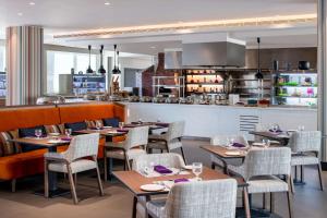 a restaurant with tables and chairs and a kitchen at DoubleTree Suites by Hilton - Riyadh Financial District in Riyadh