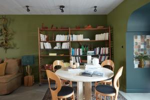 ein Zimmer mit einem Tisch, Stühlen und einem Bücherregal in der Unterkunft Maisons 322 - L'Insolite in Le Bois-Plage-en-Ré