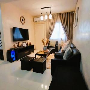 a living room with a couch and a tv at Stellar Homesharing 1 in Davao City