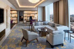 リヤドにあるDoubleTree Suites by Hilton - Riyadh Financial Districtのリビングルーム(ソファ、椅子付)