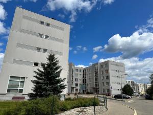 a tall white building with a tree in front of it at Quiet 1BR in Serene neighborhood in Rīga