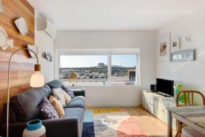 uma sala de estar com um sofá e uma janela em Apartamento T1 - Salina Ria em Aveiro