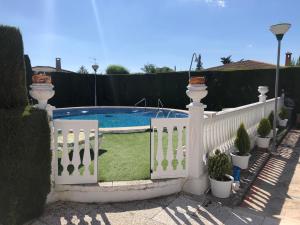 una valla blanca junto a una piscina con plantas en El rincón de Dory, en Martos