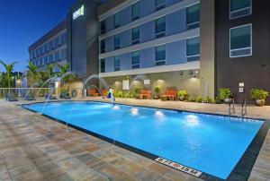 una gran piscina frente a un edificio en Home2 Suites by Hilton Fort Myers Colonial Blvd, en Fort Myers