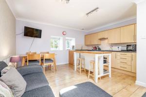 a kitchen and a living room with a couch and a table at Barn Cottage 2 bedroom with gorgeous views in Dunblane