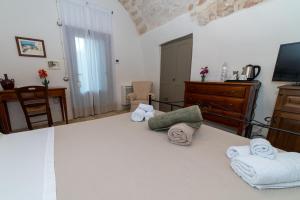 a room with a bed with towels on it at Masseria Lamiola Piccola in Ostuni