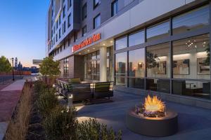 Hilton Garden Inn Camden Waterfront Philadelphia في Camden: حفرة حريق أمام مبنى