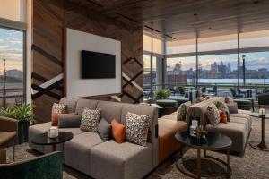 uma sala de estar com um sofá e uma televisão em Hilton Garden Inn Camden Waterfront Philadelphia em Camden