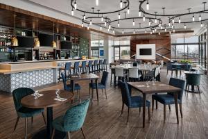 a restaurant with tables and chairs and a bar at Hilton Garden Inn Camden Waterfront Philadelphia in Camden
