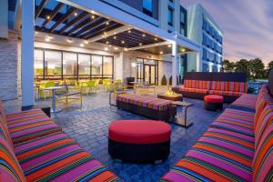 d'une terrasse avec des meubles colorés, des tables et des chaises. dans l'établissement Home2 Suites By Hilton Lewisburg, Wv, à Lewisburg