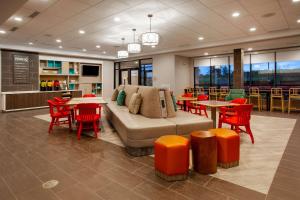 ein Wohnzimmer mit einem Sofa, Tischen und Stühlen in der Unterkunft Home2 Suites By Hilton Lewisburg, Wv in Lewisburg