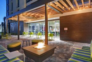 a patio with a table and chairs and a fire pit at Home2 Suites By Hilton Largo, Fl in Largo