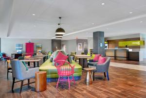 um átrio com mobiliário colorido, mesas e cadeiras em Home2 Suites By Hilton Largo, Fl em Largo