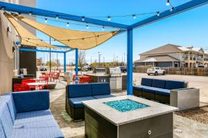 un patio con muebles azules, mesa y sillas en Tru By Hilton Midland, Tx, en Midland