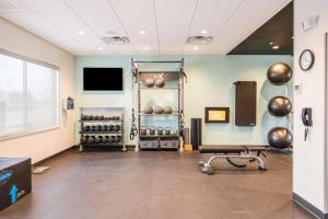 een kamer met een fitnessruimte met gewichten en een televisie bij Tru By Hilton Midland, Tx in Midland