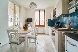uma cozinha com mesa e cadeiras num quarto em Elysee em La Spezia