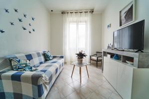 uma sala de estar com um sofá e uma televisão de ecrã plano em Elysee em La Spezia