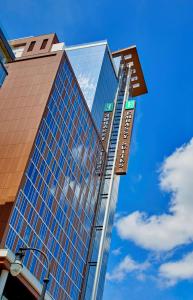 un grand bâtiment en verre avec un ciel bleu en arrière-plan dans l'établissement Embassy Suites by Hilton Nashville Downtown, à Nashville