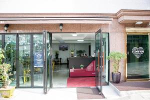an open glass door of a building with a red couch at Dream Guesthouse in Seoul