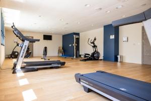 a gym with treadmills and exercise bikes in it at Hôtel Le Bastia in Bastia