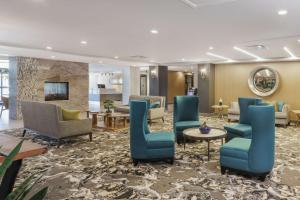 un vestíbulo de un hotel con sillas y mesas azules en Hotel Trilogy Albany Airport, Tapestry Collection by Hilton, en Latham