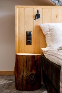 コシチェリスコにあるKu Dolinieのベッドルーム1室(ベッド1台、ベッドスカートの横に木製の切り株付)