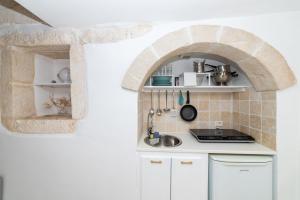 - une cuisine avec une arche en pierre et un évier dans l'établissement Casa Debora, à Ostuni