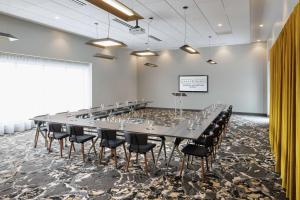 una gran sala de conferencias con una mesa larga y sillas en Hotel Trilogy Albany Airport, Tapestry Collection by Hilton, en Latham
