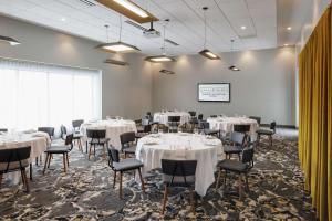 una sala de conferencias con mesas y sillas blancas en Hotel Trilogy Albany Airport, Tapestry Collection by Hilton, en Latham