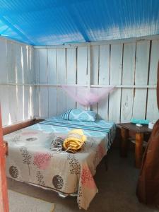 ein Schlafzimmer mit einem Bett mit blauer Decke in der Unterkunft FINCA AGROTURISTICA VILLA MANE in San José del Guaviare