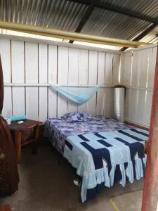 a bedroom with a blue and white bed and a table at FINCA AGROTURISTICA VILLA MANE in San José del Guaviare