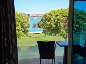 a table and chairs in a room with a view of the water at Apartments Riva-Interauto in Umag