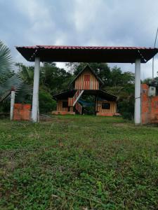 una piccola casa con un padiglione in un campo di FINCA AGROTURISTICA VILLA MANE a San José del Guaviare