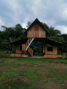 ein Haus mit einem Gamer-Dach und einer Veranda in der Unterkunft FINCA AGROTURISTICA VILLA MANE in San José del Guaviare