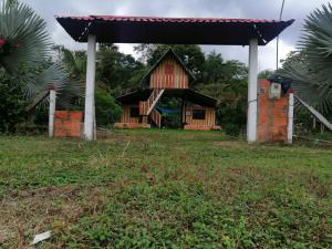 ein kleines Haus mit einem Pavillon auf einem Feld in der Unterkunft FINCA AGROTURISTICA VILLA MANE in San José del Guaviare