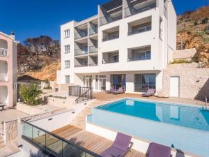 an apartment with a swimming pool and a building at Villa Cascada in Podgora