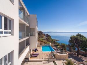a view of a building with a swimming pool and the ocean at Villa Cascada in Podgora