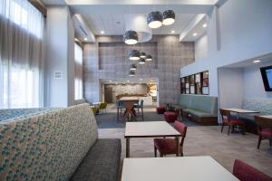 un hall avec des tables et des chaises ainsi qu'une salle d'attente dans l'établissement Hampton Inn North Attleboro, Ma, à North Attleboro