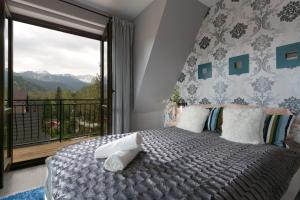 1 dormitorio con 1 cama y balcón con vistas. en VIP Apartamenty Widokowe, en Zakopane