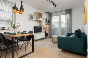 a living room and dining room with a table and chairs at Trendy Warsaw Apartment with 2 Bedrooms, Balcony & Parking by Renters in Warsaw