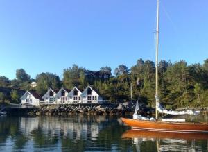Bømlo的住宿－阿施姆羅博爾酒店，船坐在房子前面的水里