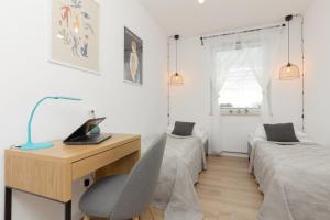 a bedroom with two beds and a desk with a laptop at Trendy Warsaw Apartment with 2 Bedrooms, Balcony & Parking by Renters in Warsaw