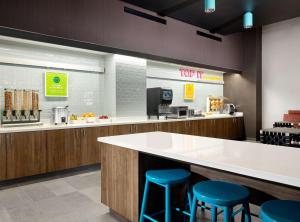 a kitchen with a counter and blue stools at Tru By Hilton Indianapolis Downtown, In in Indianapolis