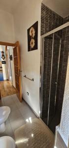 uma casa de banho com um chuveiro e uma porta de vidro em Nonna Giusy em Alghero