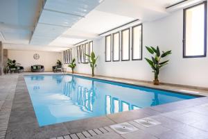 巴斯蒂亚Hôtel Le Bastia的窗户客房内的蓝色海水游泳池