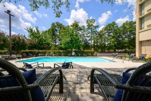 a swimming pool with lounge chairs at DoubleTree by Hilton Raleigh Midtown, NC in Raleigh