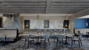 uma sala de jantar com mesas e cadeiras e um bar em DoubleTree by Hilton Raleigh Midtown, NC em Raleigh