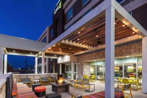 an outdoor patio with chairs and a fire pit at Home2 Suites By Hilton Midland East, Tx in Midland
