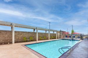 - une piscine avec des tables et des chaises sur la terrasse dans l'établissement Home2 Suites By Hilton Midland East, Tx, à Midland