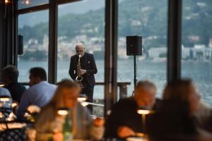 a man playing a saxophone in a restaurant at Bella Hotel & Restaurant with private dock for mooring boats in San Felice del Benaco